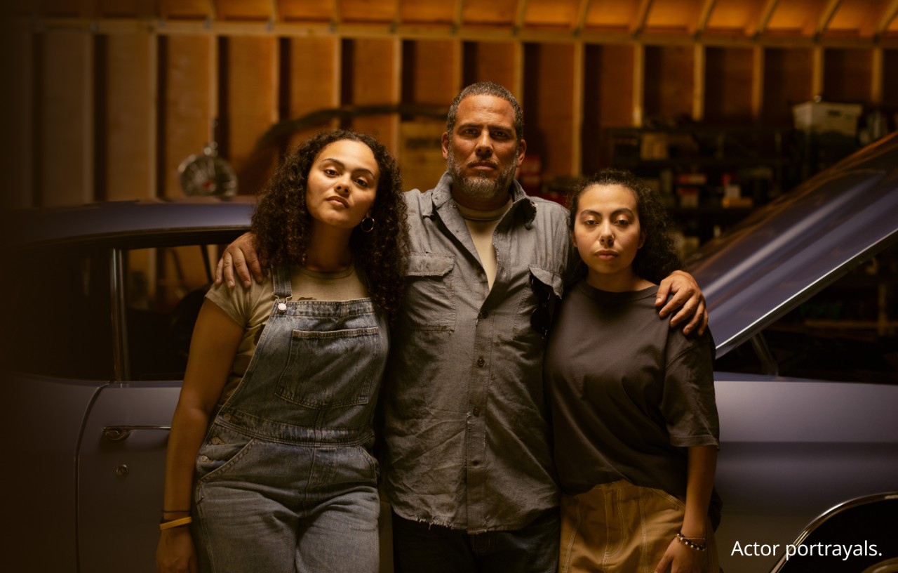 Man standing in front of car with daughters