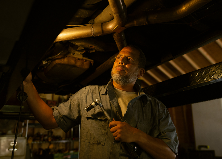 Man examining the undercarriage of a car
