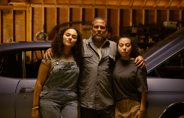 Man standing in front of car with daughters