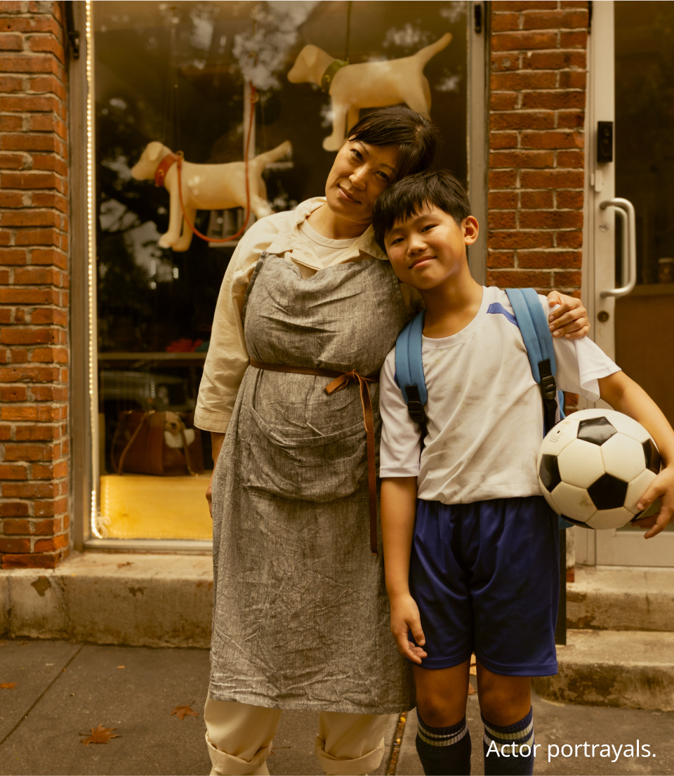 Woman standing with her son in front of her grooming salon
